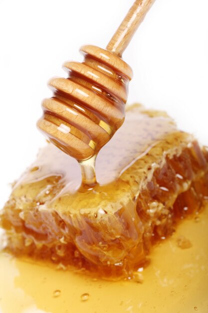 Honey dripping from a wooden spoon