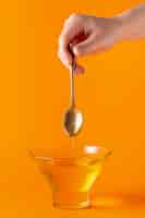 Free photo honey dripping off spoon in bowl