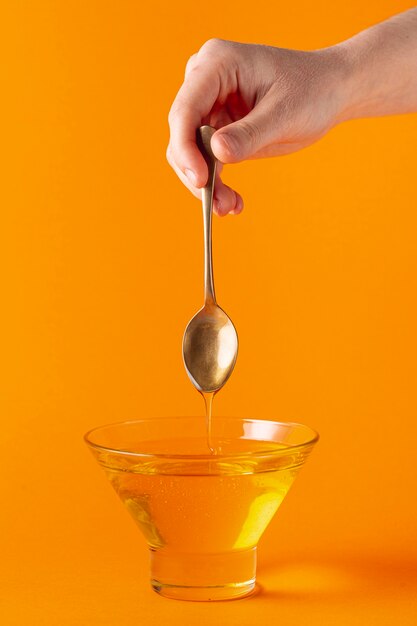 Honey dripping off spoon in bowl