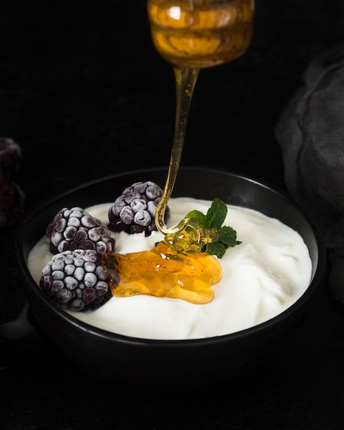 Foto gratuita sgocciolatura del miele nella fine del yogurt in su