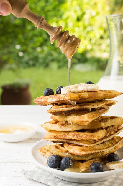 Honey falling on waffle tower