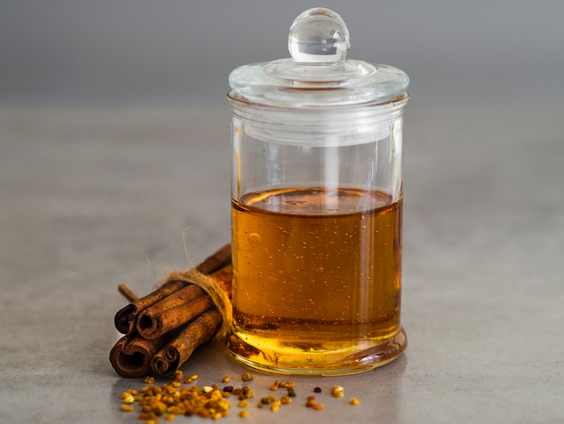 Honey jar next to cinnamon sticks