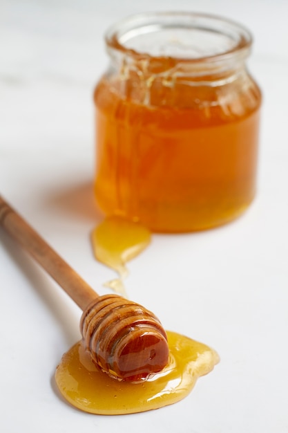 木製のハニーディッパーが付いている蜂蜜の瓶