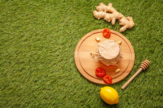 Honey jar on a wooden board and ginger