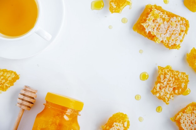 Free photo honey products composition. honey in jar, honeycomb, tea and special spoon. white background