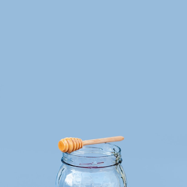 Free photo honey stick on a jar with copy space