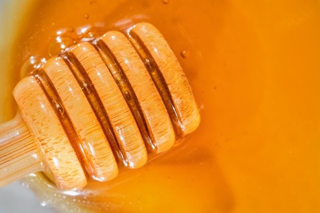 白い受け皿のクローズ アップ トップ ビューにあるハチミツのディッパーとハチミツ トルコの農場からの天然製品天然蜂製品にフラットを置く