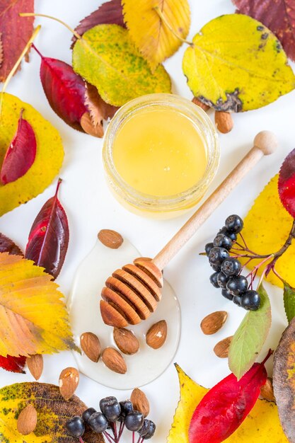 Honey with nuts in autumn leaves