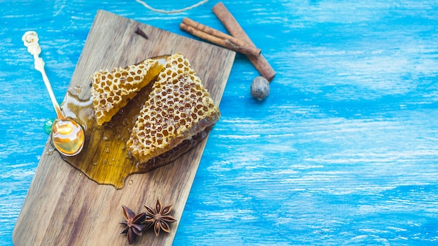 Honeycomb pieces and spices on blue textured background