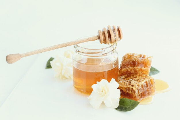 Honeycomb with jar and flowers