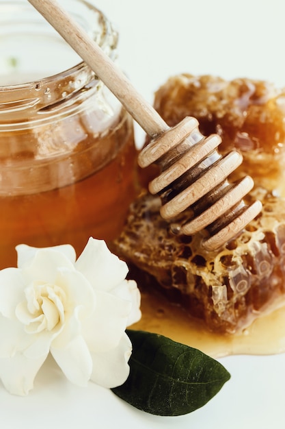 Free photo honeycomb with jar and flowers