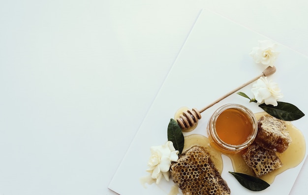 Free photo honeycomb with jar and flowers