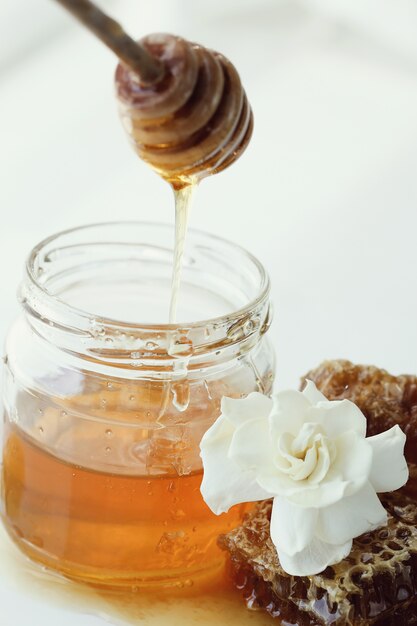 Honeycomb with jar and flowers