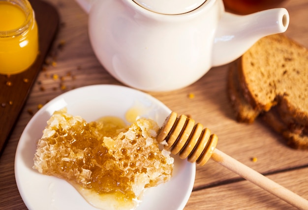 Honeycomb with tea and bread on table