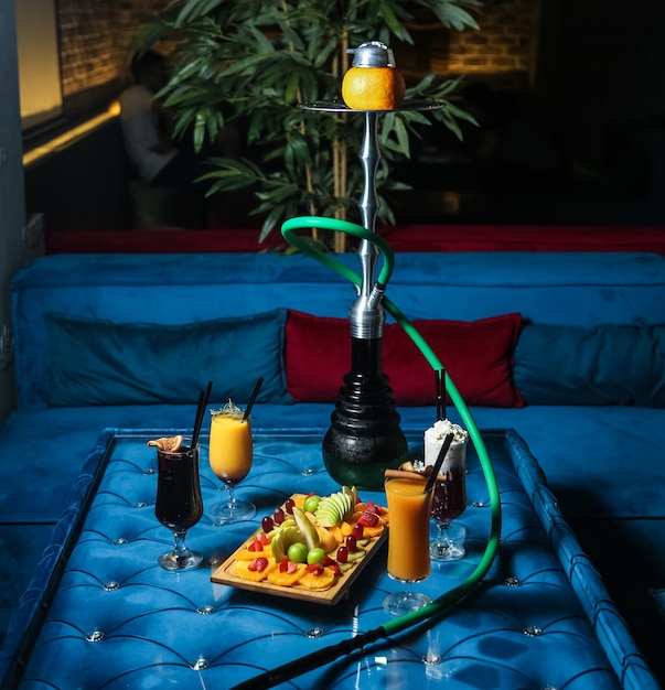 Free photo hookah with mixed fruits on the wooden board and cocktails side view