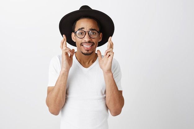 Hopeful african-american guy pleading, begging god, cross fingers good luck