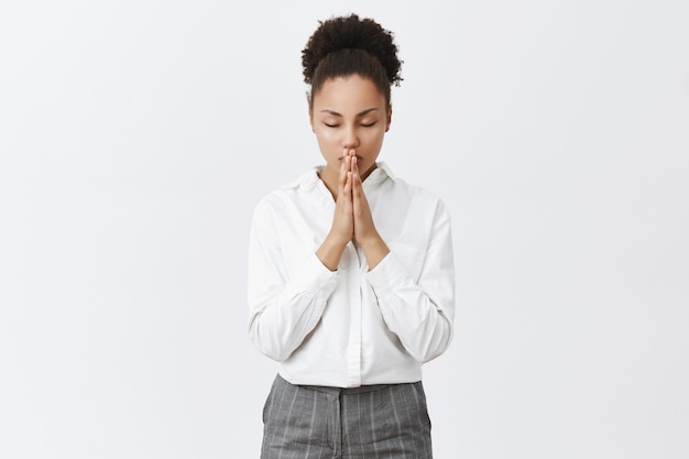 Hopeful african-american woman praying, pleading or making wish