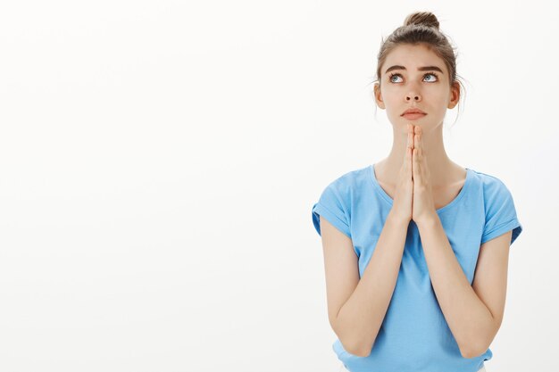 Hopeful beautiful young woman longing for something, praying or supplicating