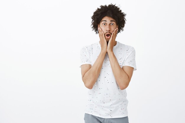 Hopeful dark-skinned man looking surprised and amazed with big news