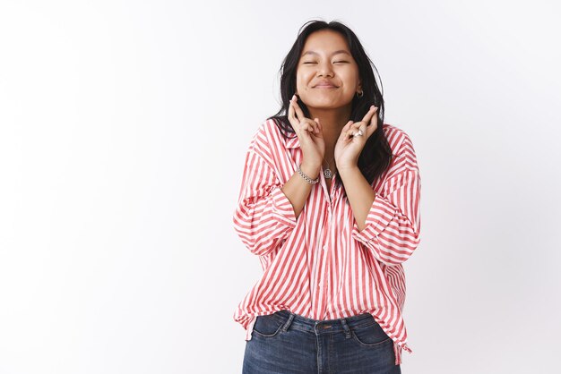 Hopeful and optimistic cute excited    asian woman  crossing fingers