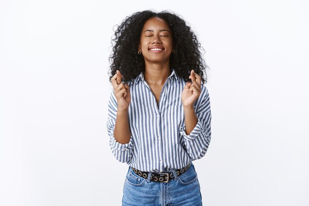 Hopeful optimistic happy charming african american woman cross fingers for positive news.