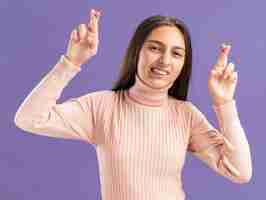 Бесплатное фото Обнадеживающая симпатичная девочка-подросток делает жест удачи обеими руками, изолированными на фиолетовой стене