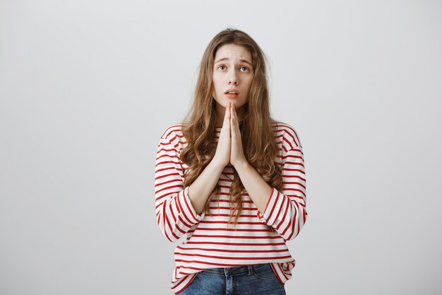 Бесплатное фото Обнадеживающая грустная девушка умоляет, разговаривает с богом или молится