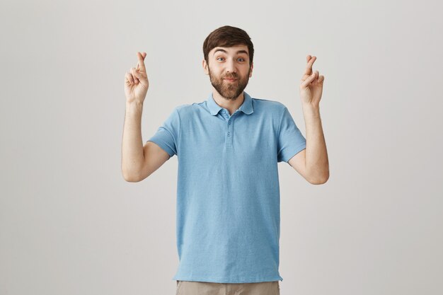 Hopeful smiling young bearded man posing