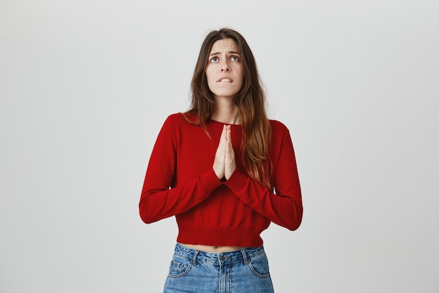 Hopeful worried girl praying god. Woman hold hands together and looking sky pleading