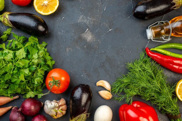Горизонтальный вид на свободное пространство круглой формы, свежие овощи, упавшие бутылки с маслом, яйца, лимоны, специи на черном фоне