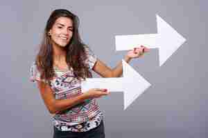 Free photo horizontal arrows in hands of young woman