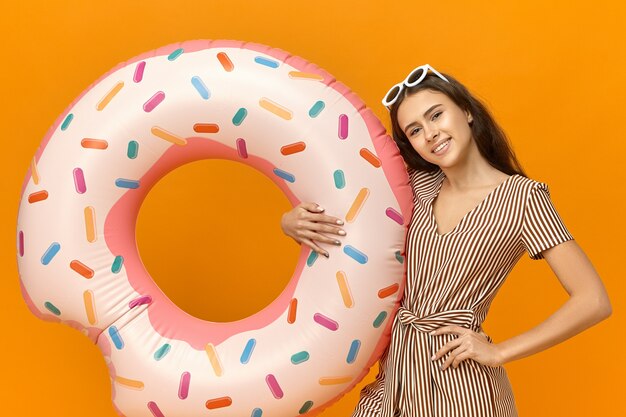 Horizontal image of carefree joyful young Caucasian girl learning how to swim