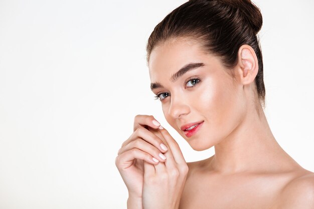 Horizontal portrait of beautiful young woman having fresh skin posing with hands together