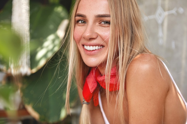 Free photo horizontal portrait of glad adorable woman with white perfect teeth, dressed casually