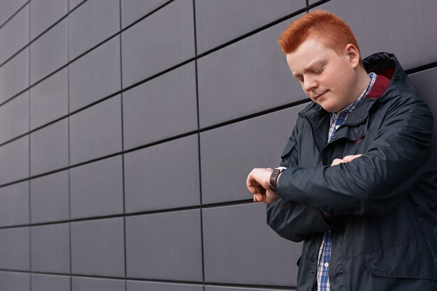 A horizontal portrait of handsome redhead freckled boy with stylish haircut dressed in black jacket p