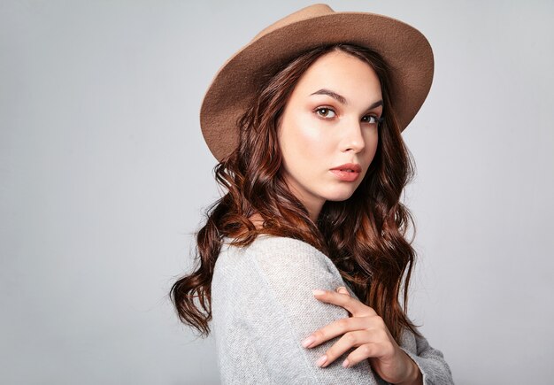 Horizontal portrait of stylish attractive female model wears summer clothes and brown hat with natural makeup