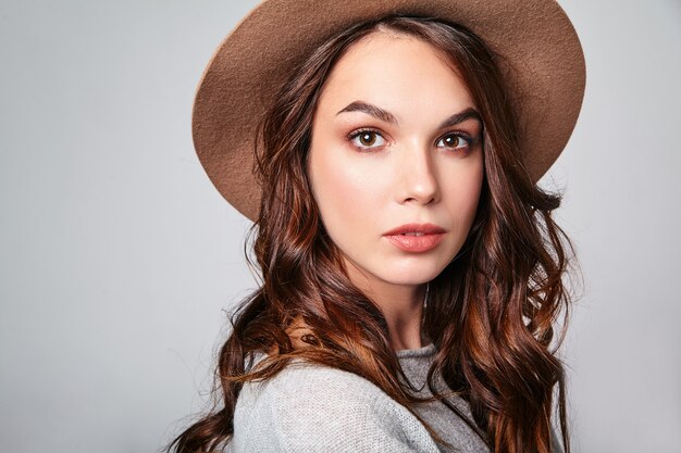 Horizontal portrait of stylish attractive female model wears summer clothes and brown hat with natural makeup