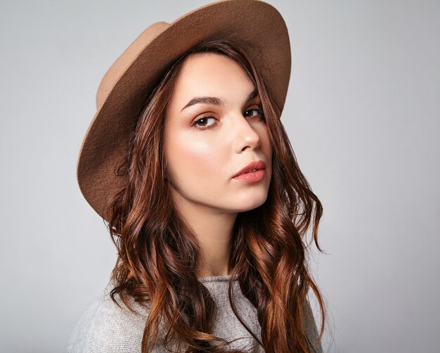 Horizontal portrait of stylish attractive female model wears summer clothes and brown hat with natural makeup