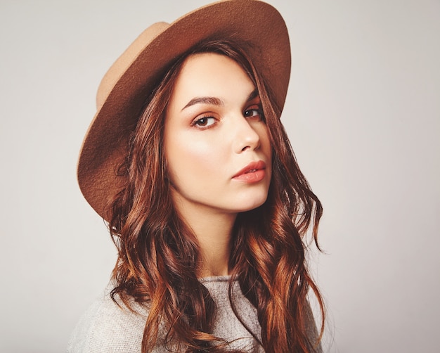 Horizontal portrait of stylish attractive female model wears summer clothes and brown hat with natural makeup