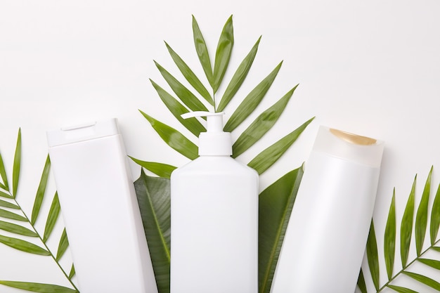 Free photo horizontal shot of cosmetic products against greenery or leaves.
