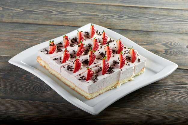 갓 구운 된 맛있는 치즈 케이크의 가로 샷 최고 나무 테이블 과자 요리 베이킹 디저트 아침 달콤한 개념에 딸기 장식.