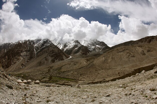 Horizontal shot of high rise rocky mountains near the Karakoram highway in China covered in snow