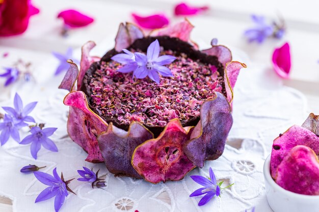 Horizontal shot of a pear raw vegan purple cake with dehydrated pears on a white tabletop