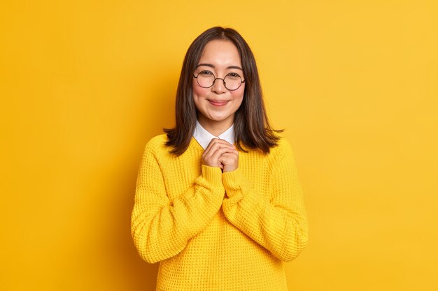 Horizontal shot of pleased Asian woman