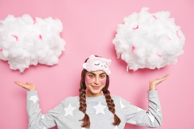 Free photo horizontal shot of pleased brunette woman has two combed pigtails wears pajama