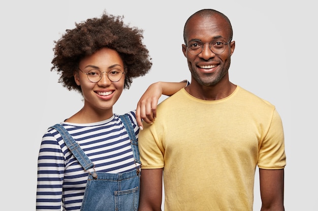 Free photo horizontal shot of pleased young african american man and woman have gentle smiles