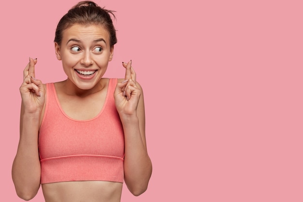 Free photo horizontal shot of pleased young woman with sporty body