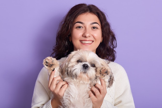 Horizontal shot of positive funny model with peaceful facial expression