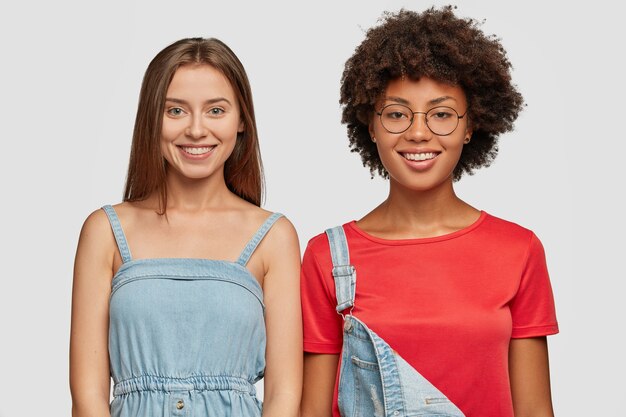 Horizontal shot of smiling women dressed in denim clothing