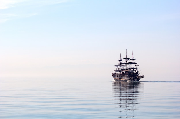 Horizontal shot of a tall ship sailing on beautiful clear water during daylight
